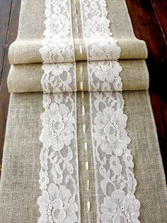 three burlap table runners with white lace on them