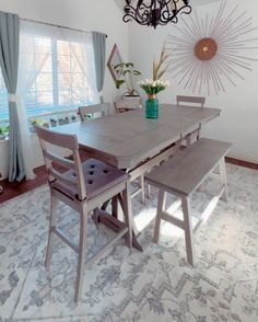 a dining room table with two chairs and a bench