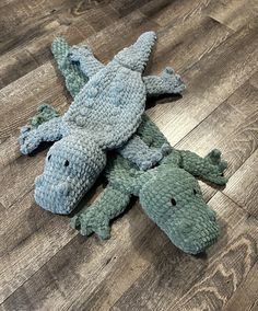 two stuffed alligators are laying on the floor