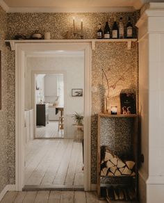 an open door leading into a room with wooden floors and wallpaper on the walls