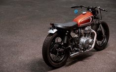 an orange and black motorcycle is parked on the street in front of some concrete walls