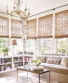 a living room filled with furniture and windows covered in shades of bamboo covering the window