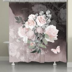 a shower curtain with flowers and a butterfly on the bottom, in front of a gray background