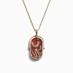 a red and gold necklace with an image of a bird on the inside of it