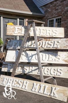 an old wooden sign sitting in front of a house