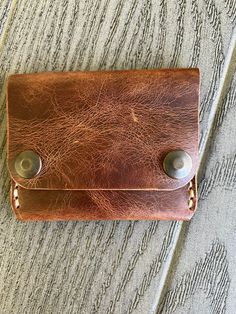 This handmade leather wallet offers three inner pockets with a snap closure.  Measurements: 102 mm X 80 mm when snapped 102 mm X 149 mm when open -- [ CARE INSTRUCTIONS ] -- * Remove dust and dirt with a soft brush or cloth. * Refrain from using detergents or chemicals. Use a damp cloth to wipe your wallet lightly and allow to air dry. * Allow them to dry naturally and never under an artificial heat source. * If the leather gets too dry, apply a neutral leather cream or conditioner on the wallet to moisturize the leather. *Please note colors may vary slightly. We try to capture the colors the best we can.* If you have any questions, please do not hesitate to contact me. Brown Leather Wallet With Snap Closure, Bifold Coin Purse With Snap Closure, Handmade Brown Wallet For Everyday Carry, Brown Bifold Coin Purse With Snap Closure, Rectangular Trifold Wallet With Snap Closure As Gift, Vintage Brown Trifold Wallet For Everyday Carry, Brown Bifold Wallet With Snap Closure, Hand-stitched Trifold Wallet For Everyday Use, Rustic Leather Wallets With Card Slots