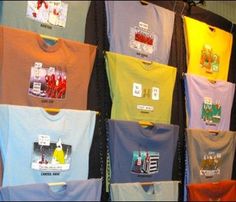 t - shirts are hanging on the wall in front of each other, with different colors and designs