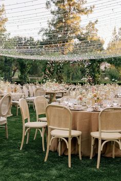 an outdoor wedding reception with tables and chairs set up in the grass for guests to eat