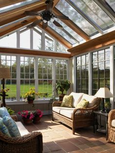 a sun room with wicker furniture and large windows