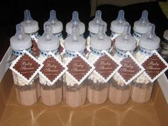 baby shower favors are arranged in glass bottles with labels on the top, and brown polka dots