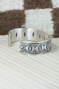 This sterling silver bracelet was made by Navajo silversmith Calvin Martinez. The inside is signed C MTZ, Navajo and stamped sterling.Size: 5 3/8" (will fit up to a 6 3/8" wrist)Gap: 1"Width: 5/8"Free shipping on all orders! We ship with USPS and always include tracking. All orders ship within a day of payment.Returns are accepted up to 30 days after you receive your order. Just send us a message. Our shop offers cash back or store credit. The item must be returned in new condition. Southwestern Silver Cuff Bracelet With Inlay, Adjustable Etched Sterling Silver Southwestern Bracelet, Adjustable Etched Southwestern Sterling Silver Bracelet, Southwestern Sterling Silver Stamped Bangle Bracelet, Southwestern Style Stamped Sterling Silver Bangle Bracelet, Southwestern Style Stamped Sterling Silver Bangle, Southwestern Style Etched Sterling Silver Bracelet, Sterling Silver Inlay Bracelets In Silver Color, Southwestern Sterling Silver Bracelet