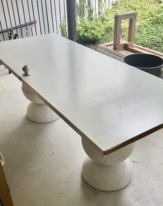 a long white table sitting in the middle of a room next to a large window