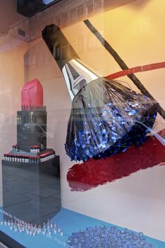 a window display with an image of a building and other items in the glass behind it