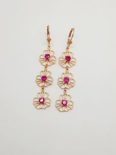 925 Sterling Silver, 18K gold plating, Lever back earrings, Triple flower earrings, Flower earrings,, Ruby Cubic Zirkon, Romantic Gift. Material: 925 Sterling Silver  Finishing: 18K top gold plating, Vermeil Part size: Total length-65mm Gemstone: Ruby CZ 4mm SKU: 11256TG P R O D U C T - C A R E: - Separate from other jewelry to prevent scratching - Remove jewelry before exercising or showering - Polish gently using a polishing cloth - Avoid exposure to perfumes, lotions, and other chemicals O U Gold Plated Flower Earrings For Pierced Ears, Fine Jewelry Flower Drop Earrings For Pierced Ears, Anniversary Flower Charm Drop Earrings, Anniversary Flower Drop Earrings With Ear Wire, 14k Gold Flower Earrings For Pierced Ears, Dainty Gold-plated Flower-shaped Earrings, 14k Gold Drop Flower Earrings, Gold Plated Flower Earrings For Anniversary, Dainty Flower Shaped Earrings For Formal Occasions