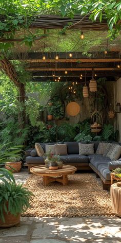 an outdoor living area with couches, tables and potted plants