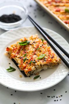 a white plate topped with food next to chopsticks