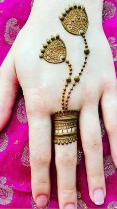 a woman's hand with henna and jewelry on top of her hands,