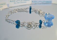 Blue beaded wire bracelet. It measures approx. 7 inches long and has a hook closure. Made with a round cornflower blue glass cabochon in the center, 4 deep turquoise blue glass square beads and swirling Peruvian Alpaca Silver wire chain. Handmade, delicate and light weight. Add it to your jewelry wardrobe. All sales are final and as is. Thank you for looking. You may also love this: https://www.etsy.com/listing/236165636/red-murano-glass-tear-drop-earrings-hoop?ga_search_query=murano&ref=sho Adjustable Blue Wire Wrapped Beaded Bracelets, Adjustable Nickel Free Glass Bracelets, Blue Wire Wrapped Bracelets With Round Beads, Blue Wire Wrapped Bracelet With Round Beads, Adjustable Blue Wire Wrapped Bracelets, Adjustable Blue Czech Glass Jewelry, Blue Wire Wrapped Beaded Bracelets, Blue Wire Wrapped Beaded Bracelets As Gift, Wire Wrapped Blue Beaded Bracelets For Gift