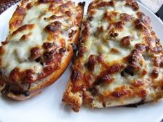 two slices of pizza sitting on top of a white plate with cheese and meat toppings