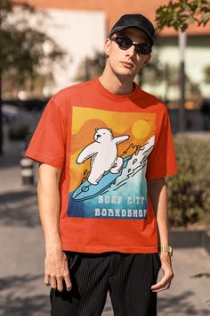 EXCLUSIVE OF DESIGN. MADE-TO-ORDER.Surf City Boardshop Polar Bear Mascot - Sunset Edition Heavyweight Tee. The unisex heavy cotton tee is the basic staple of any wardrobe. Printed on a thicker, 6.1 oz cotton jersey, the design is made to last. The specially spun 100% cotton fibers provide a smooth surface for premium vividity and sharpness. No side seams mean for extra comfort. For added durability and to prevent dropping, shoulders taping is applied. Details 100% cotton jersey (fiber content ma Casual Pre-shrunk T-shirt For Surfing, Casual Pre-shrunk Surfing T-shirt, Sporty Crew Neck T-shirt For Surfing, Casual Surfing T-shirt With Screen Print, Relaxed Fit Crew Neck T-shirt For Surfing, Casual Surfing T-shirt With Back Print, Casual Cotton Surfing T-shirt, Relaxed Fit Crew Neck Surfing T-shirt, Retro Cotton T-shirt For Surfing