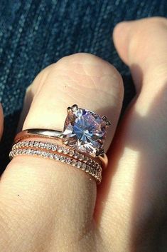 a woman's hand with a ring on it and a diamond in the middle