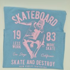 Blue t-shirt with a pink graphic of a girl skating