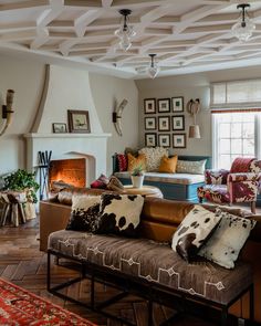 a living room filled with furniture and a fire place next to a couch in front of a window