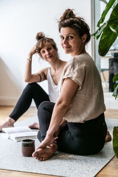 two women sitting on the floor with their feet crossed