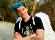 a young man with blue hair and angel wings