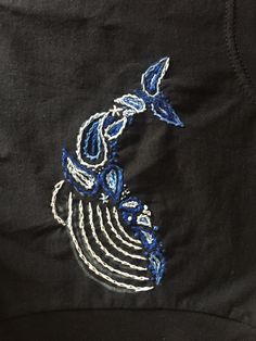 a black shirt with blue and white embroidery on it