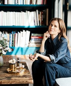 a woman sitting on a bench in front of a book shelf