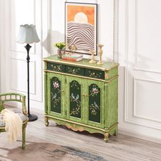 a green cabinet sitting in the corner of a room next to a lamp and chair