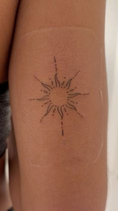 a woman's leg with a tattoo on it that has a sun in the middle