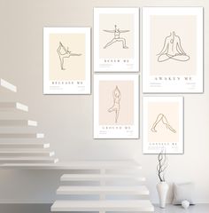 a set of four minimalist posters on the wall above a table with a vase