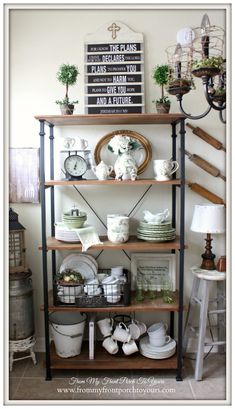 a shelf filled with lots of white dishes and other items on top of each shelf