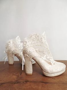 a pair of wedding shoes on top of a wooden table