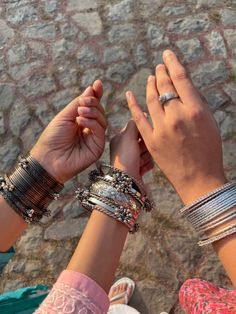 two people holding hands and wearing bracelets