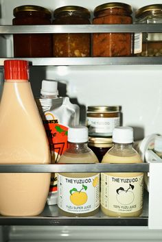 an open refrigerator filled with lots of different types of food and condiments on shelves