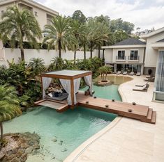 an outdoor swimming pool surrounded by palm trees