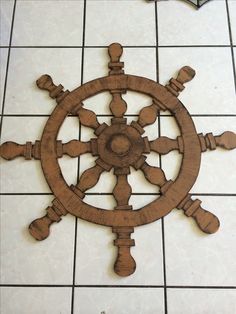 a wooden ship wheel on a tile floor