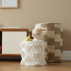 a stuffed animal sitting inside of a basket next to a wooden box with an apple in it