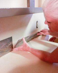 a woman with pink hair is fixing a sink