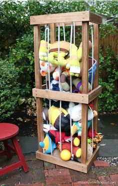 a wooden crate filled with stuffed animals in the middle of a yard next to a red table