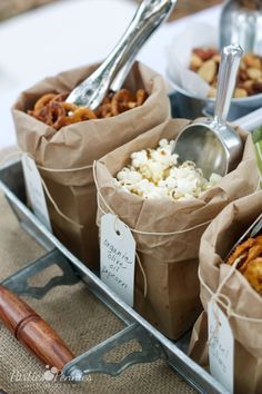 there are several bags of food on the table with spoons in them and plates