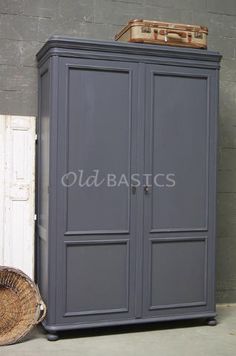 a gray armoire next to a basket on the floor