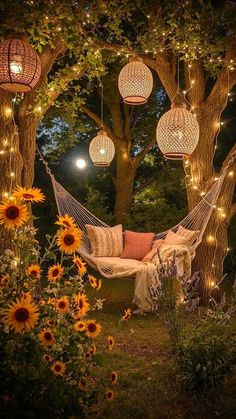 a hammock with lights hanging from it and sunflowers in the foreground