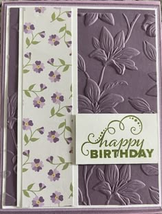 a close up of a birthday card with flowers on the front and purple, green, and white background