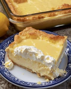 a slice of lemon pie on a plate next to a baking pan with the rest of the pie in it