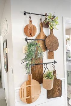 several wooden cutting boards mounted to the wall with plants in them and hanging on hooks