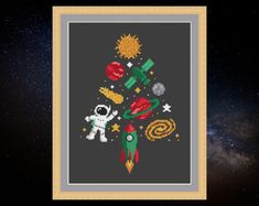 an image of a cross stitch christmas tree with space and stars in the sky behind it